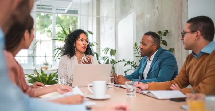 Colleagues brainstorming around an office table