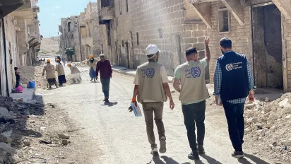 three men walking in the destroyed streets by the earthquake in Syria